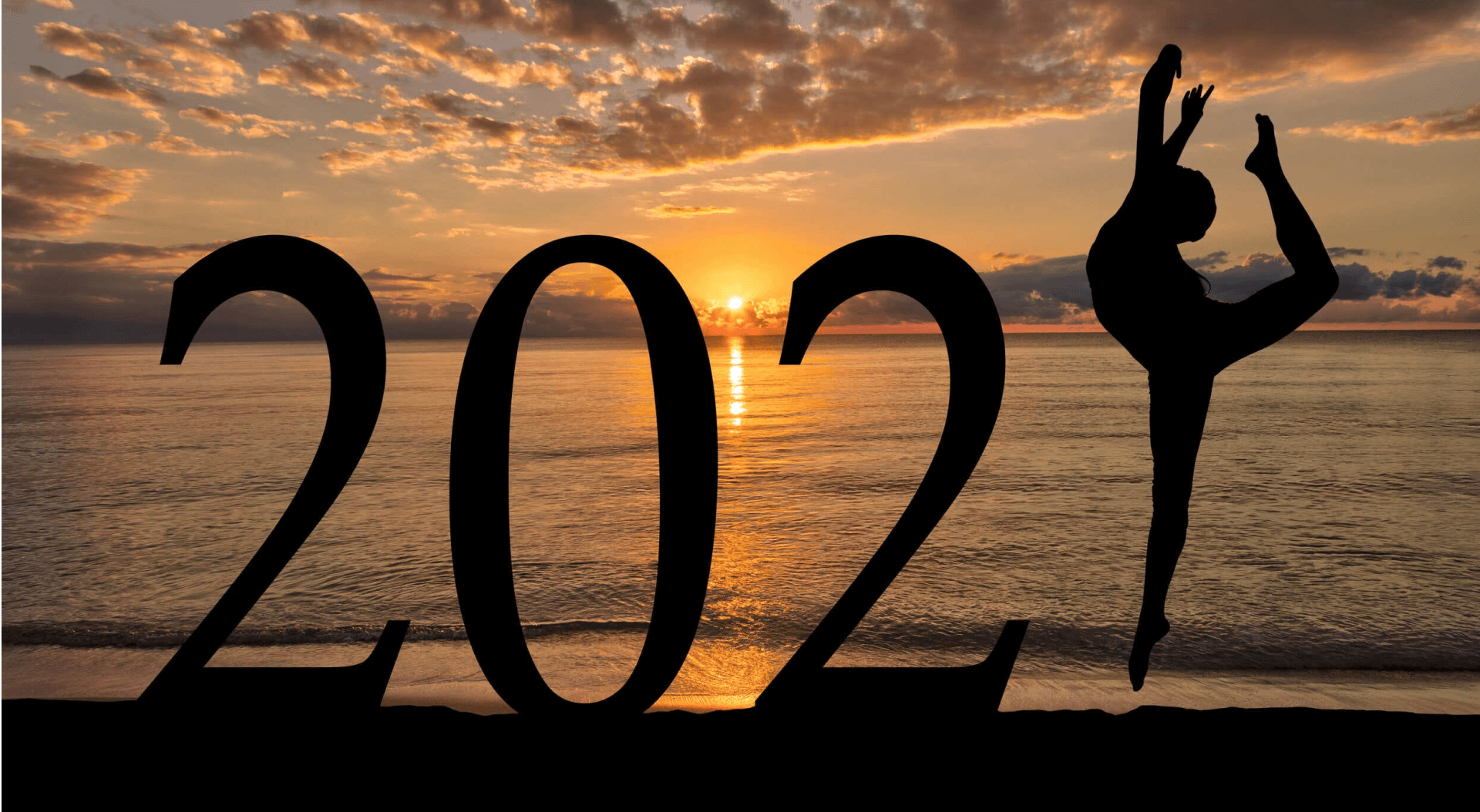 Silhouette of a person performing a yoga pose forming part of the number '2021' against a beautiful sunset on the beach.